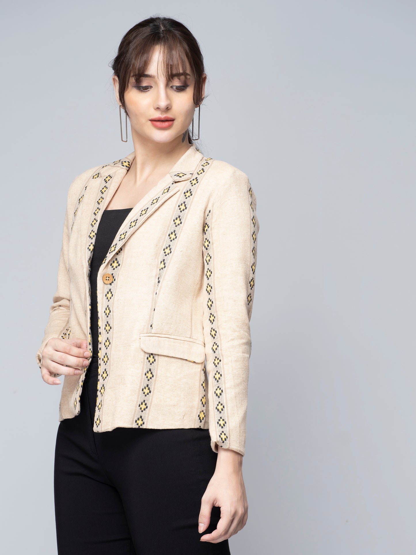 A Women in Beige & Yellow Jute Blazer, womens workwear standing against a grey background