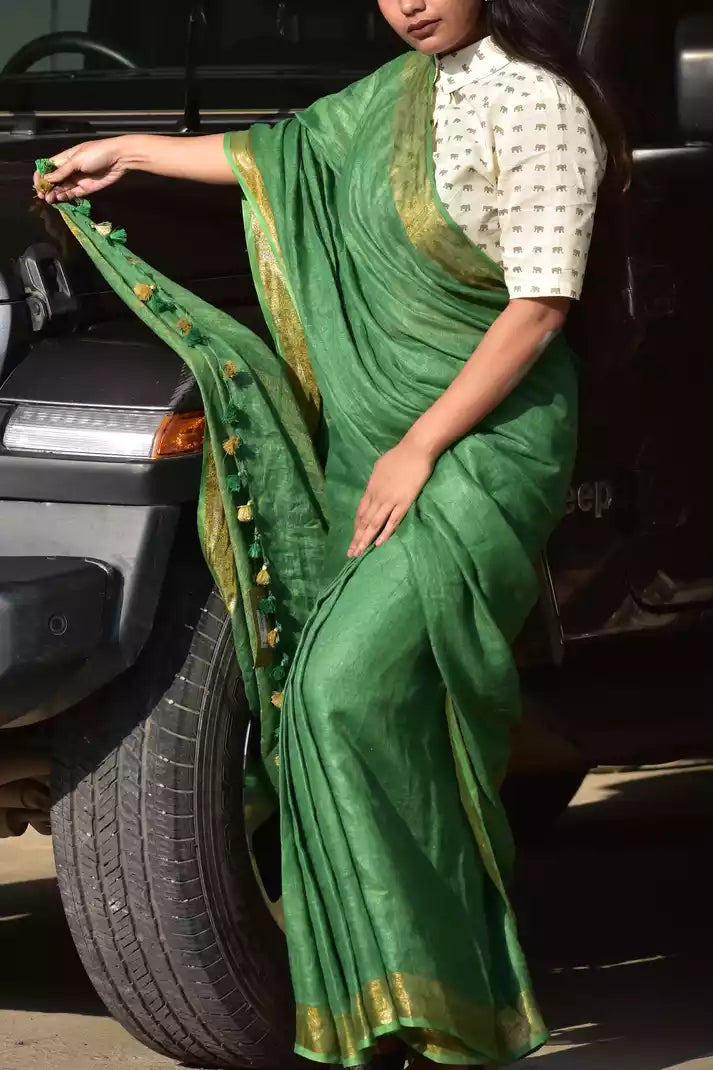 A model in Myrtle Linen Saree in Olive Green a womens workwear is standing near a jeep