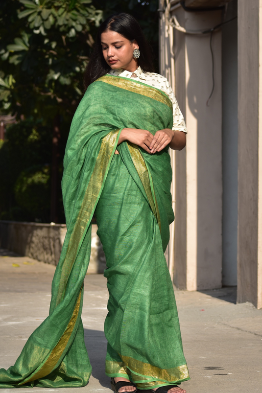 A gorgeous women in Myrtle Linen Saree in Olive Green, a office wear for women looking down