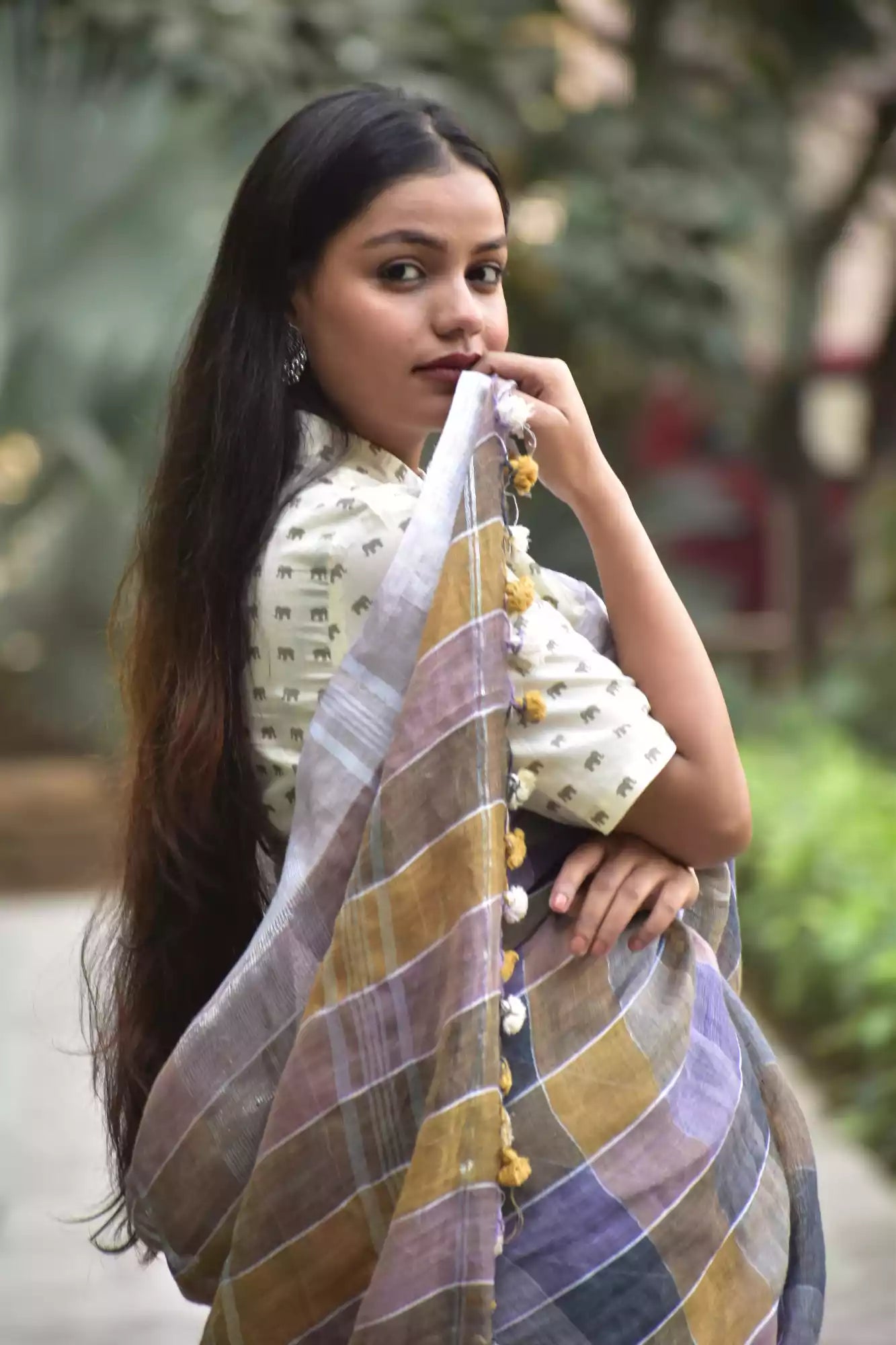beautiful posture of a woman with long hair posing wearing multicolor checks saree with collared blouse