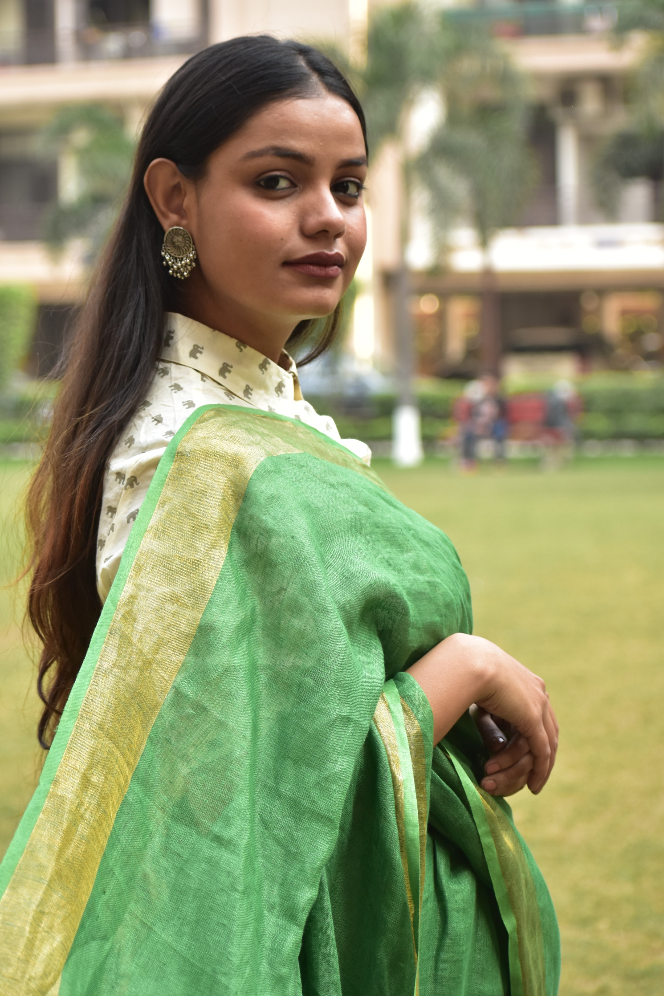 A beautiful side view of lady in Myrtle Linen Saree in Olive Green, womens workwear 