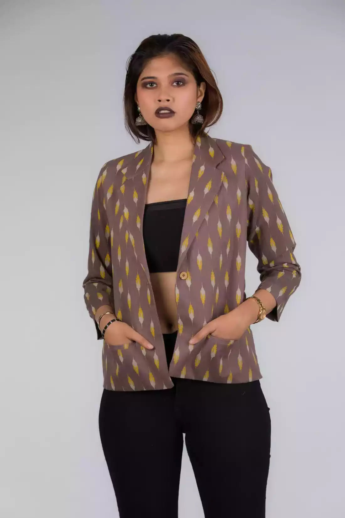 A Women in Grey Yellow Ikkat Blazer In Pure Cotton, womens workwear standing against a grey background