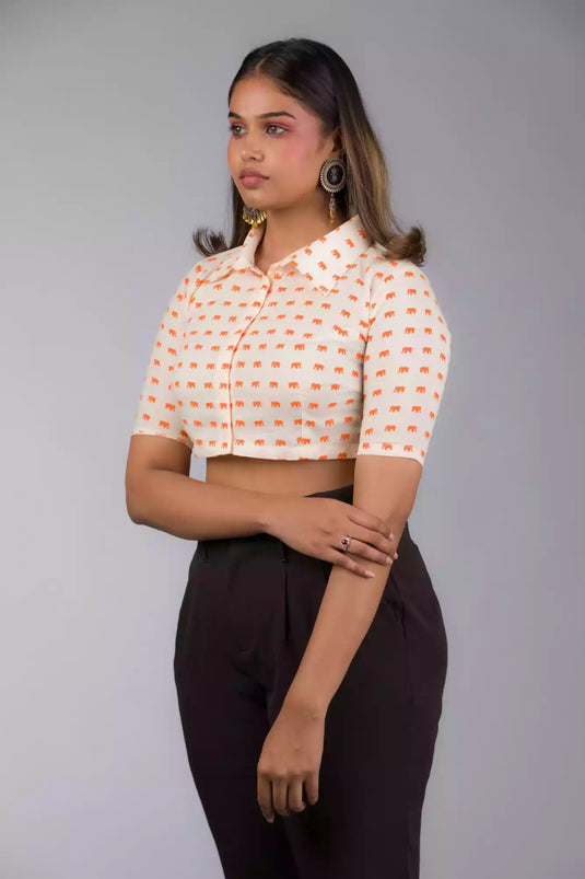A Women in Elephant Print Mul Cotton Blouse, womens workwear standing against a grey background looking sideways