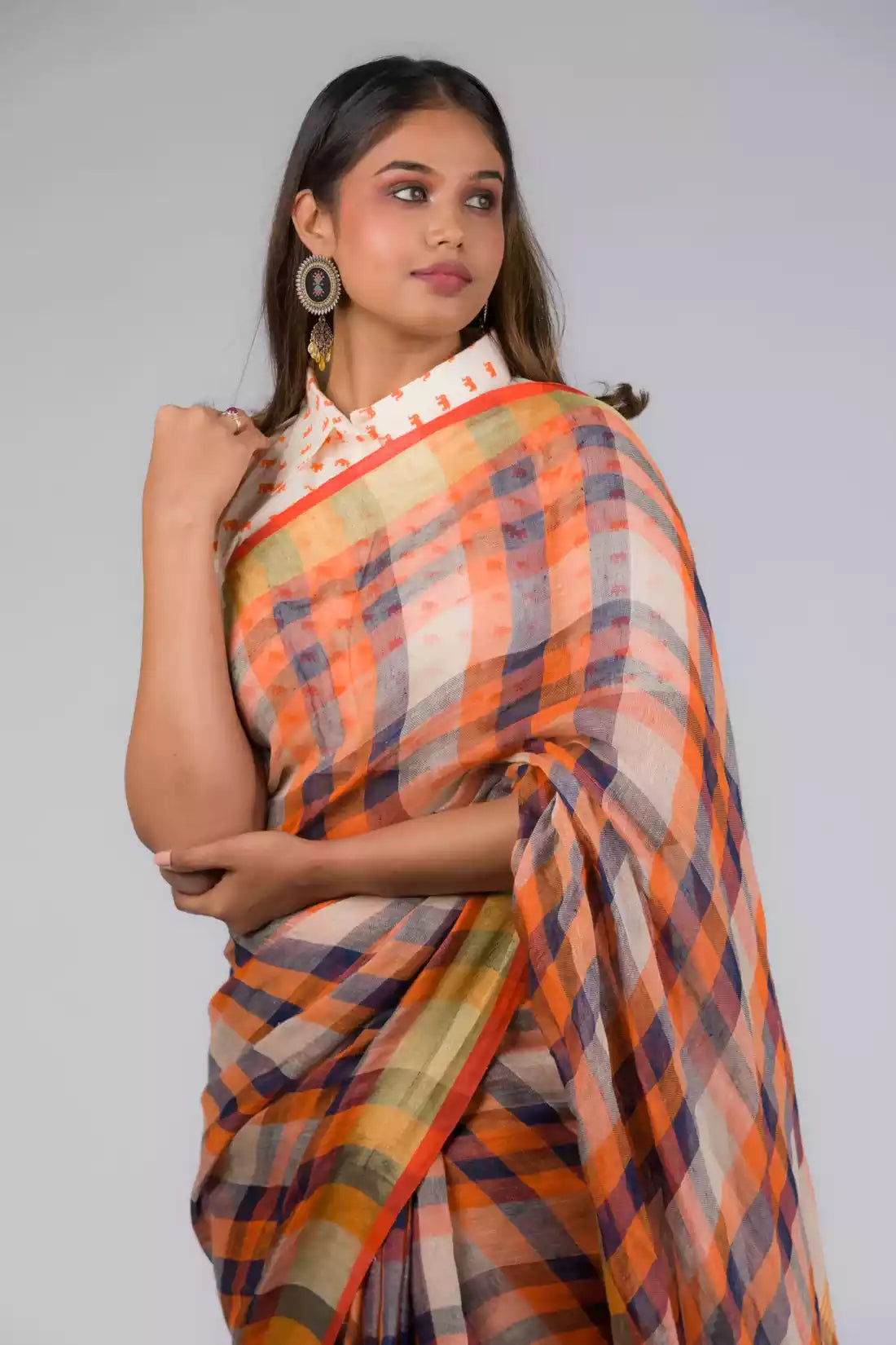 A lady in Linen By Linen Rustic Saree in Beige Checks, womens workwear standing against a beige background looking sideways