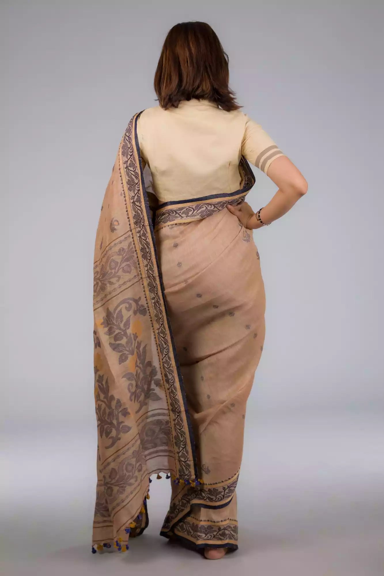 A beautiful back view of lady in Handwoven Soft Linen Cotton Saree in Beige and Black, womens workwear