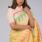 A lady in Jamdani hand weaving saree, womens workwear standing against a tan background looking down