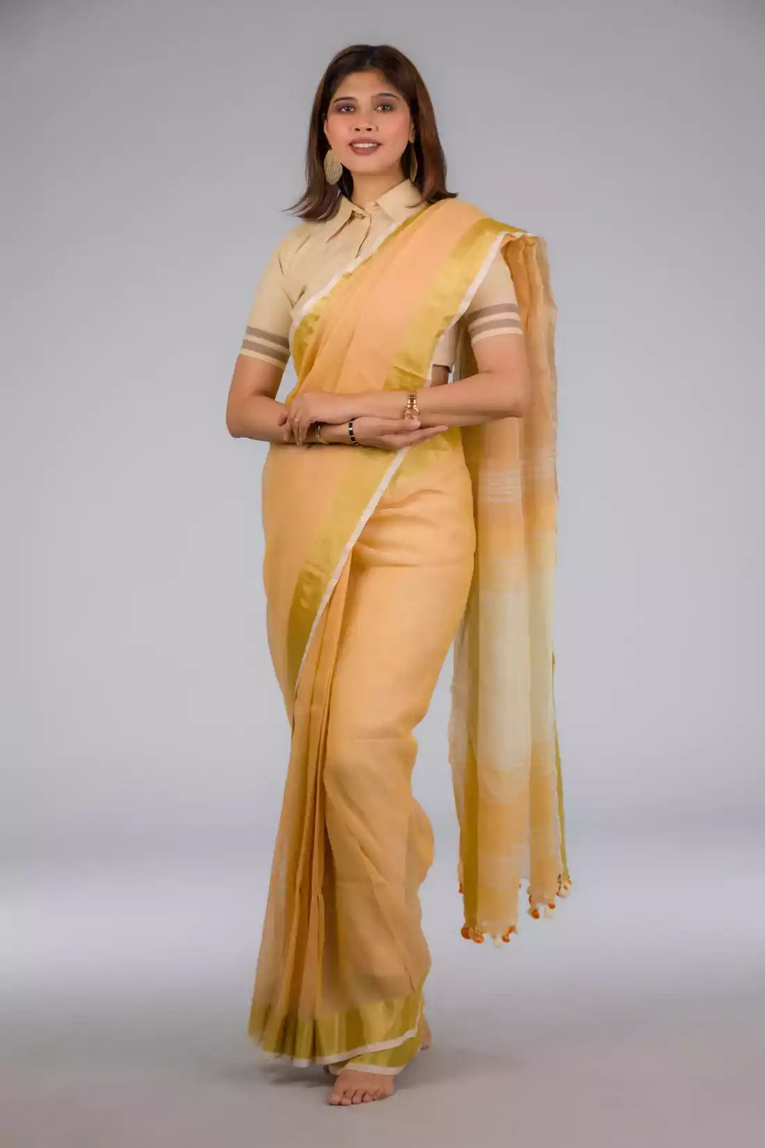 front look of a beautiful woman with short hair wearing beige saree with collared blouse