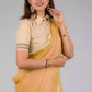 a beautiful woman with short hair posing in beige saree with collared blouse