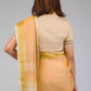 back look of a beautiful woman with short hair posing in beige saree with collared blouse