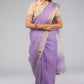 A lady in Lilac Blush Linen Saree White, womens workwear standing against a grey background looking sideways