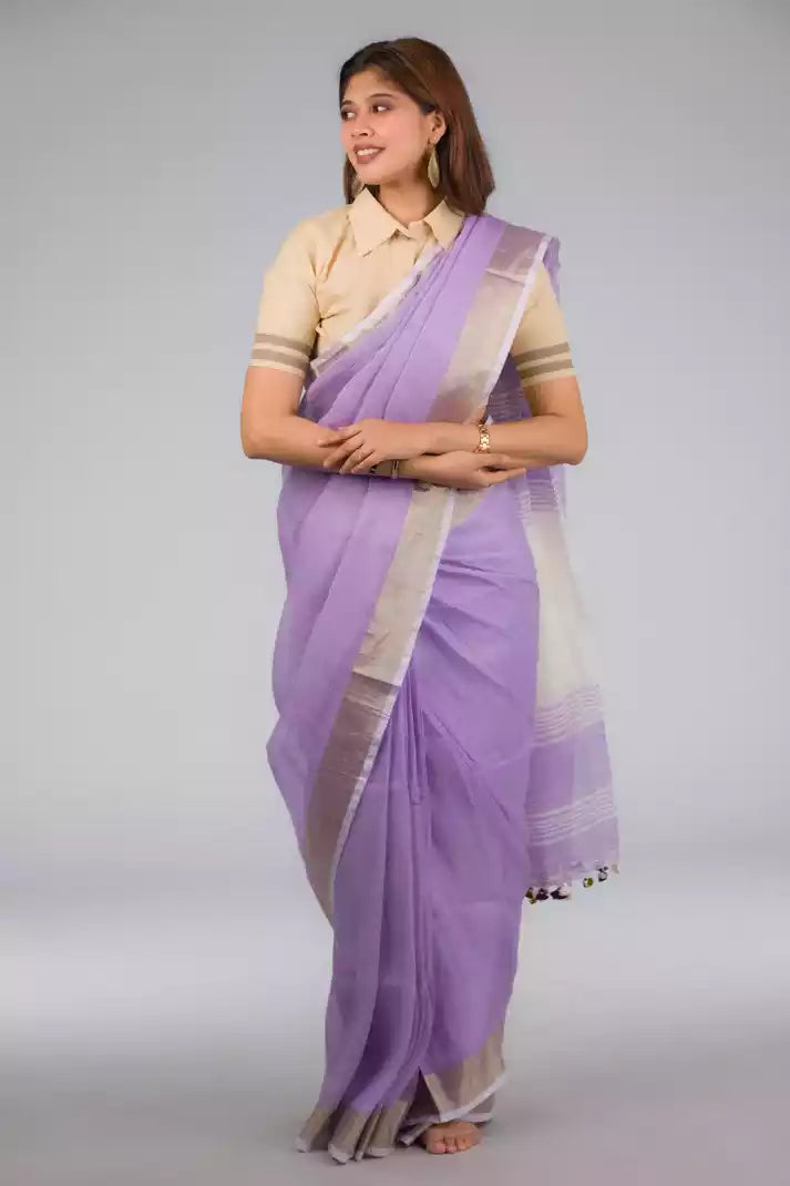 A lady in Lilac Blush Linen Saree White, womens workwear standing against a grey background looking sideways