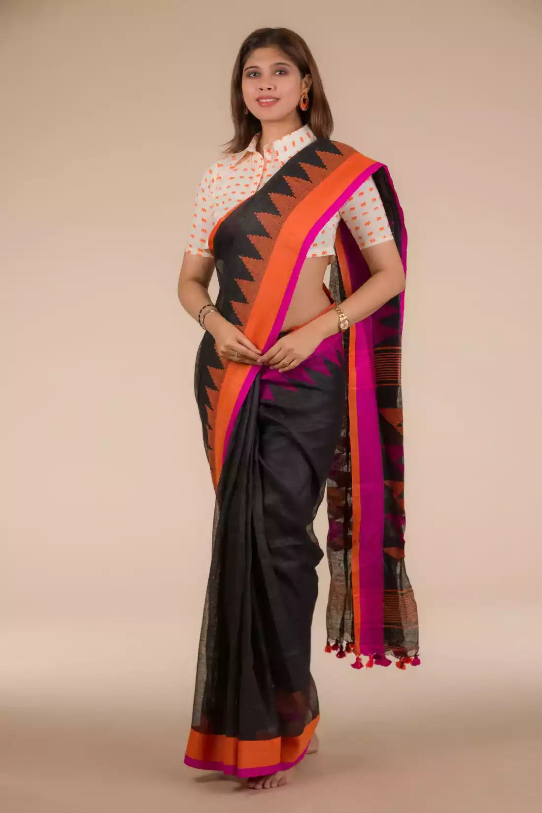 a woman in Black with Orange and pink border Jamdani hand weaving Saree, a business formal for women standing in front of a beige backdrop