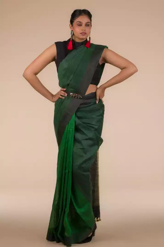 A model in Pure Linen Saree in Dual Shades of Green a womens workwear is standing against a beige background