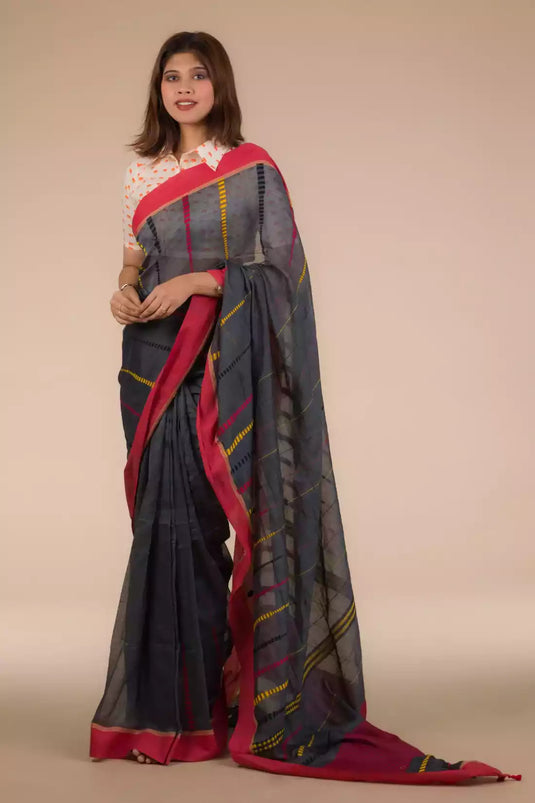 a woman in Grey and Pink border Pure Cotton Saree, a business formal for women standing in front of a beige backdrop
