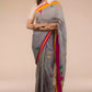 a woman in Grey-Yellow Border-pink & Green buttas Saree, a business formal for women standing in front of a beige backdrop