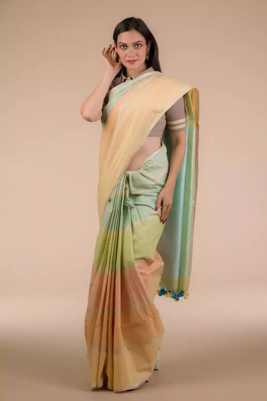 a woman in Casual Horizontal stripes Multicolor Cotton Saree, a business formal for women standing in front of a beige backdrop