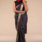 A model in Refined Dusk Linen Saree in Steel-Grey, a womens workwear is standing against a beige background