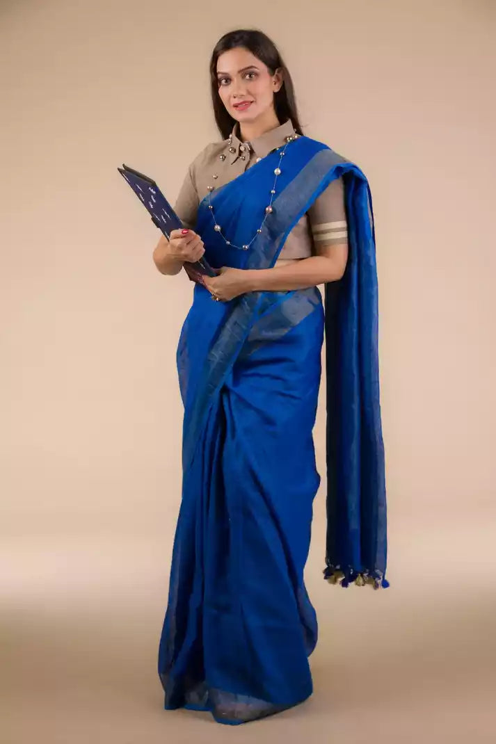 A model in Indy Pure Linen Saree in Royal Blue, a womens workwear is standing against a beige background