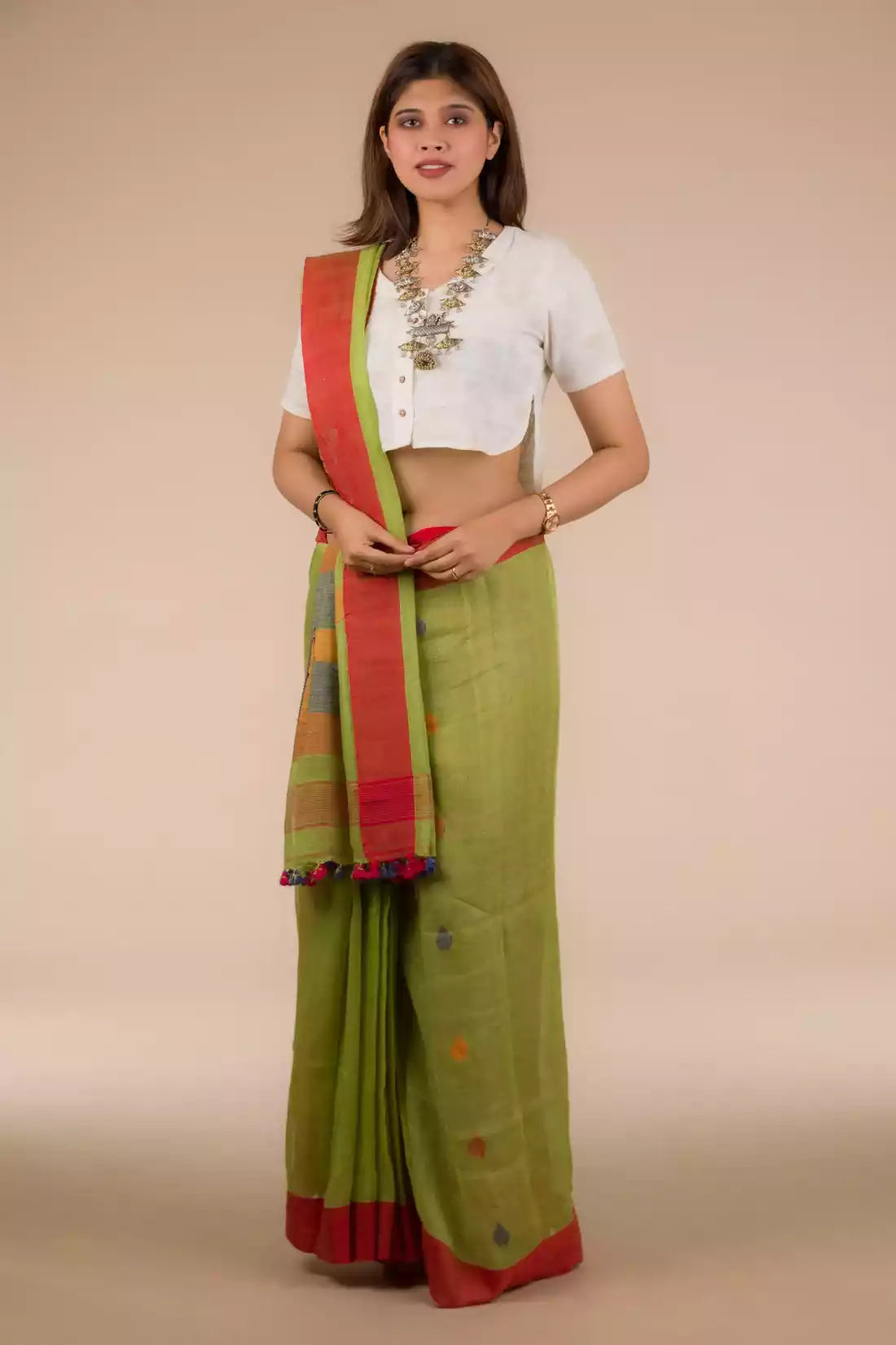  Image of a woman in Parrot Green Jamdani Pure Linen Saree, a business formal for women standing in front of a beige backdrop