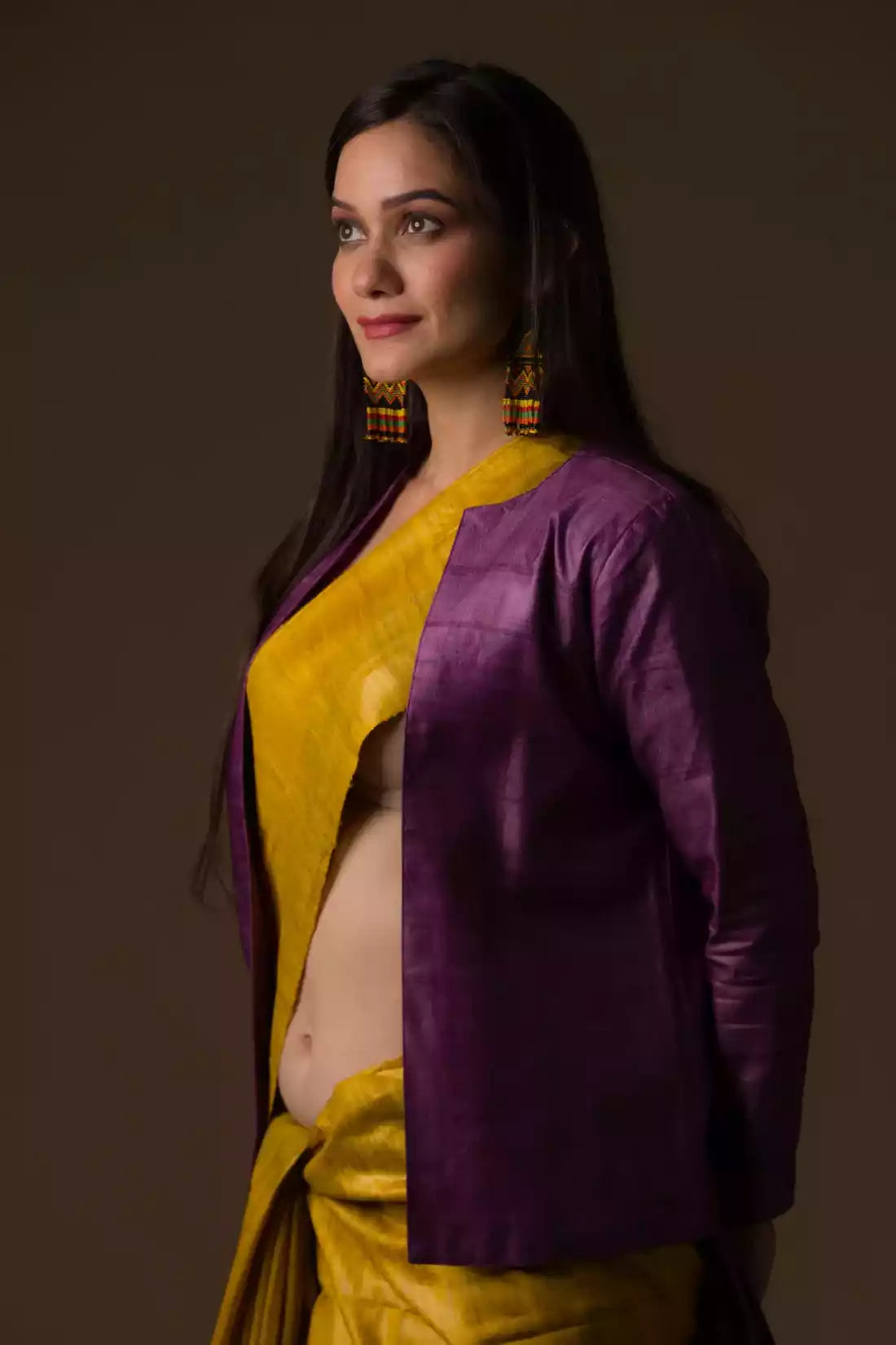 a woman looking sideways wearing formal workwear for women which is Mustard with purple border Plain In Pure Tussar with Ghicha Border Saree