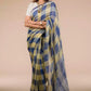 A model in Pure Linen Dark Blue Saree with Tan Brown and Lemon Yellow Checks a womens workwear is standing  against a beige background