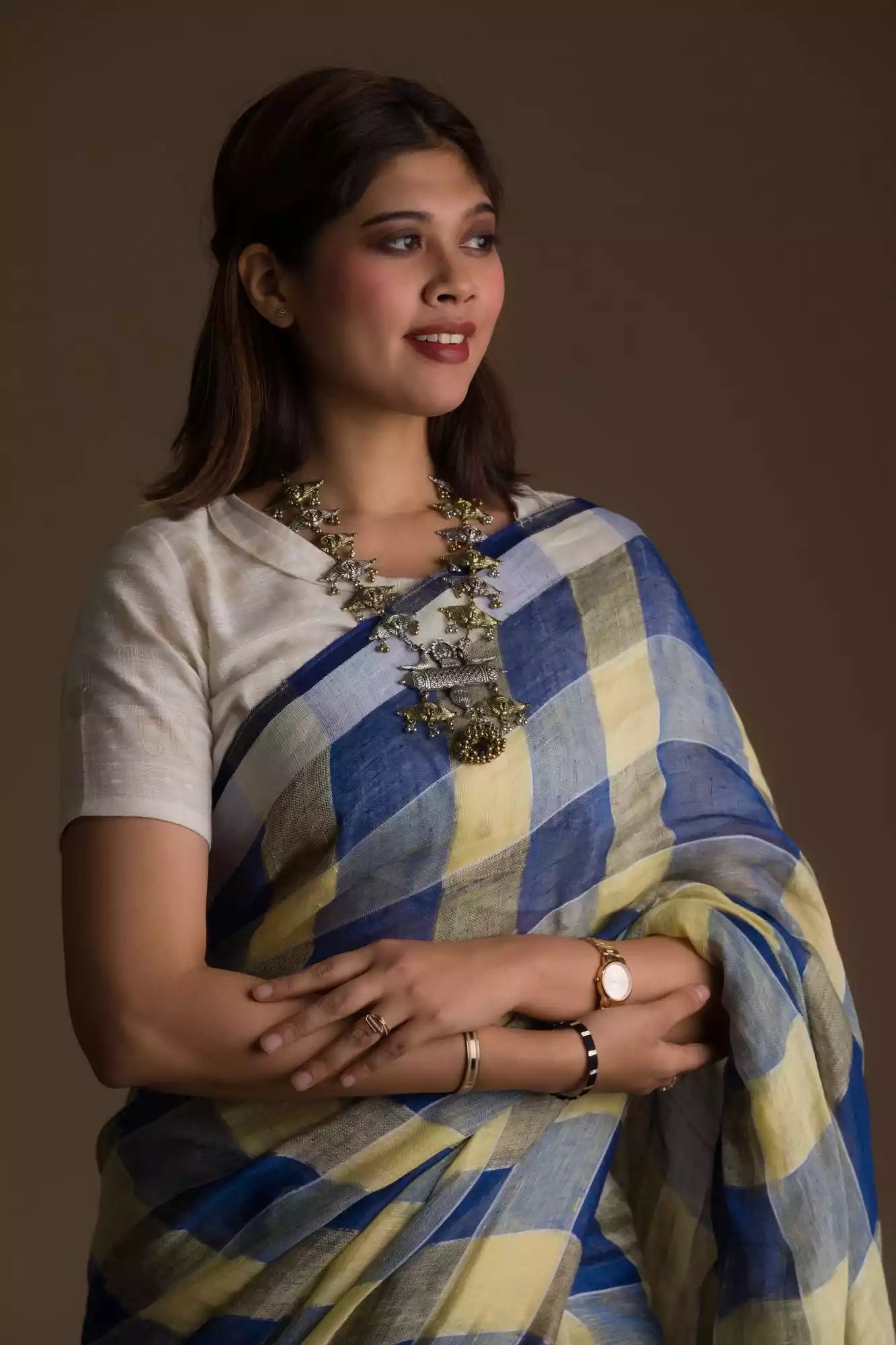 A zoomed in view of women wearing a Pure Linen Dark Blue Saree with Tan Brown and Lemon Yellow Checks, formal dress for women