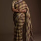 front view of a woman in ethnic posing wearing brown & beige checks saree with tie top blouse