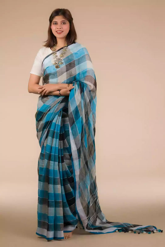 a woman in Blue Black checks In Pure Linen Saree, a business formal for women standing in front of a beige backdrop