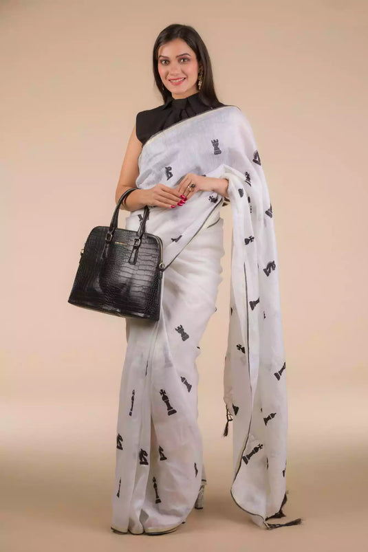 An aesthetic image of lady in Indyvarna’s Exclusive Ivory White Linen Silk Saree with Hand Embroidery, womens workwear holding a bag
