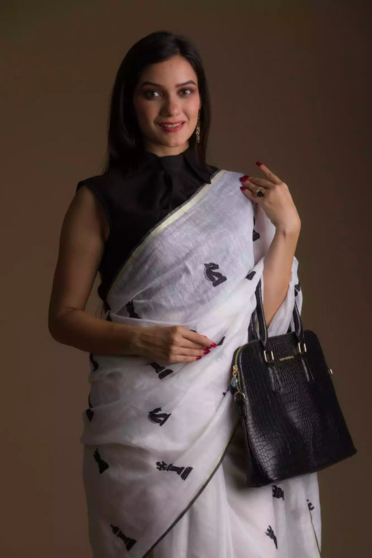 A gorgeous women in Indyvarna’s Exclusive Ivory White Linen Silk Saree with Hand Embroidery, a office wear for women 