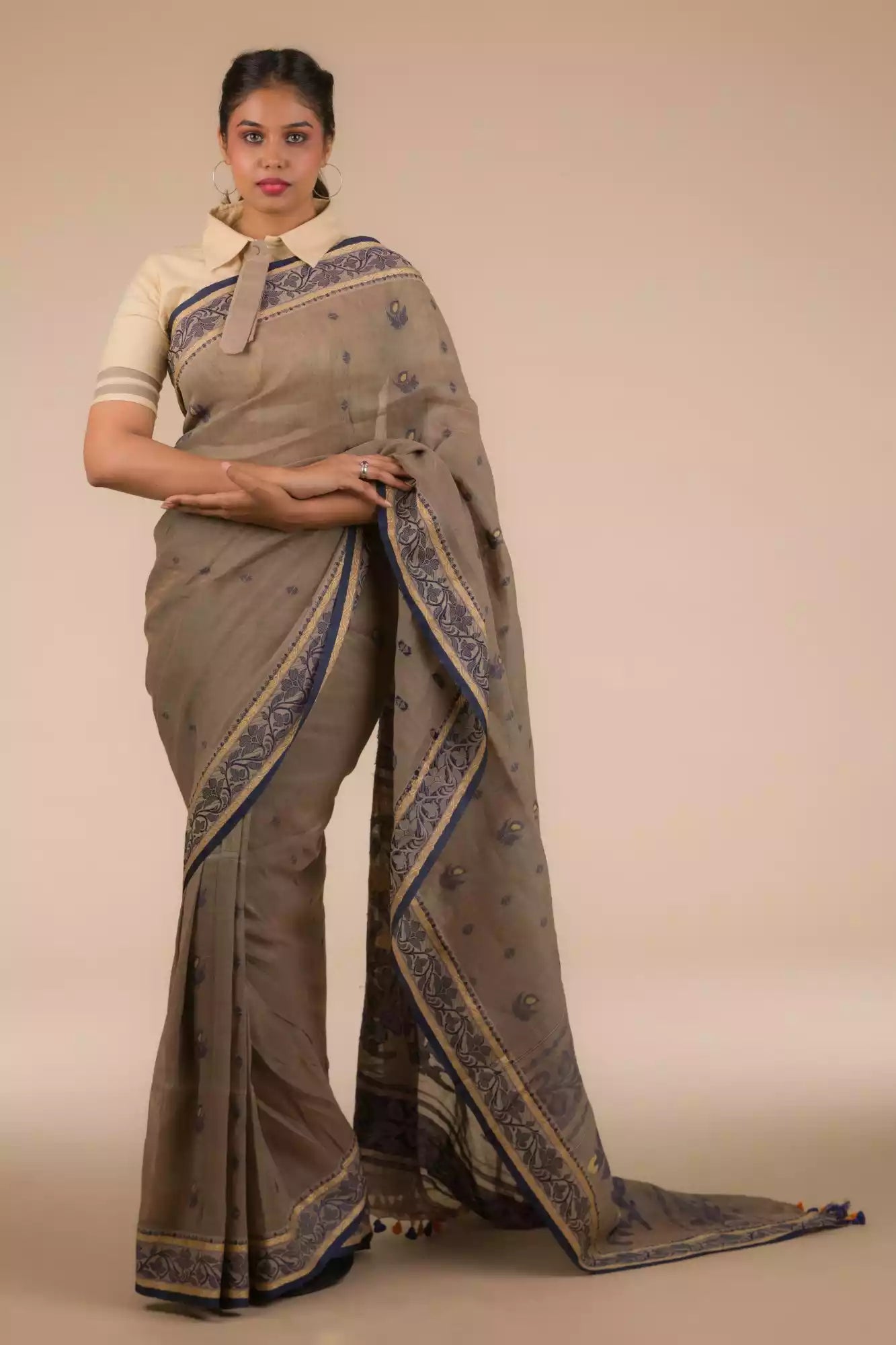 A model in Dark Beige & Black Woven Linen Cotton Saree a womens workwear is standing  against a beige background