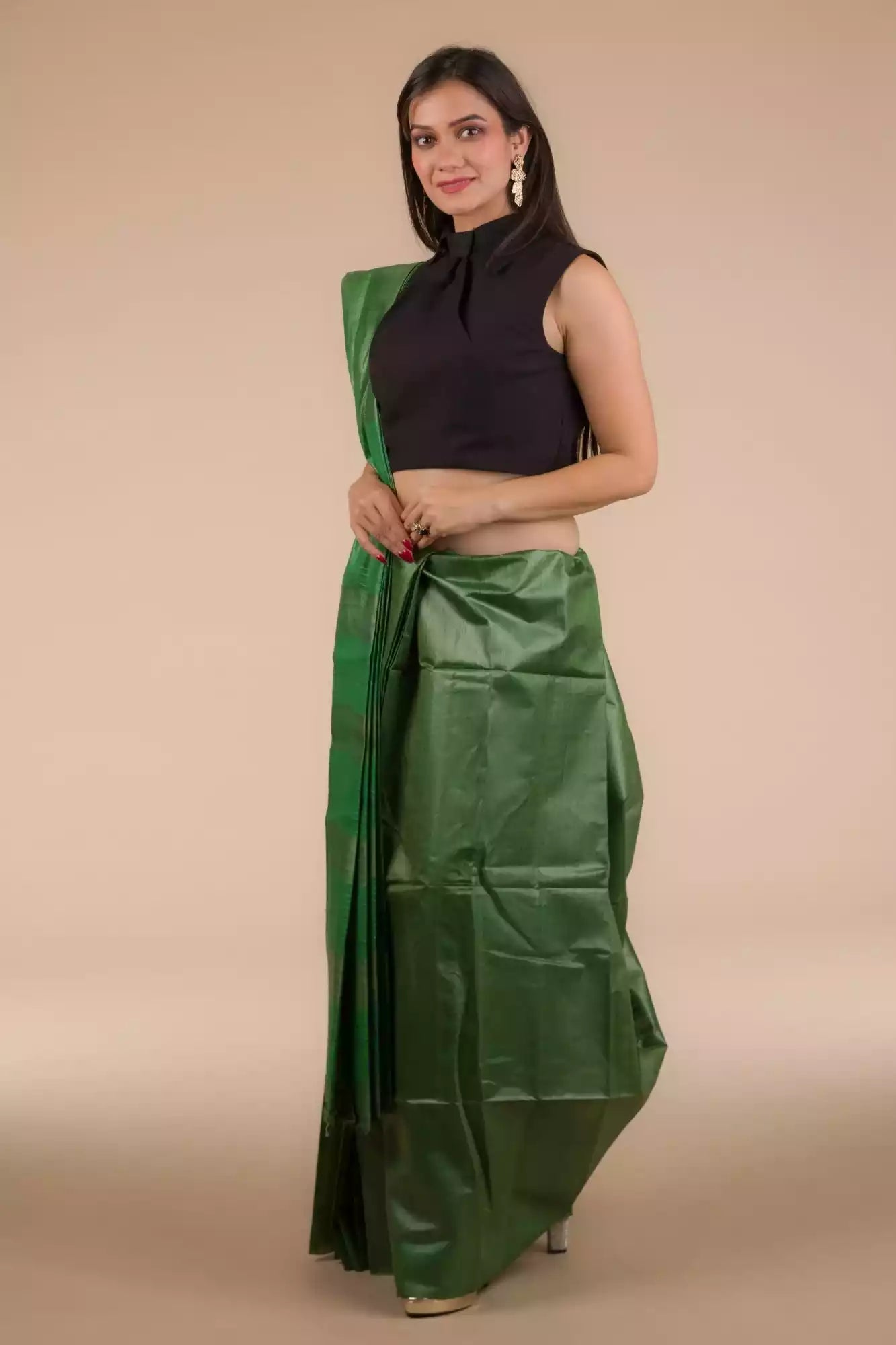 woman in ethnic posing wearing dark green saree with black blouse and heels