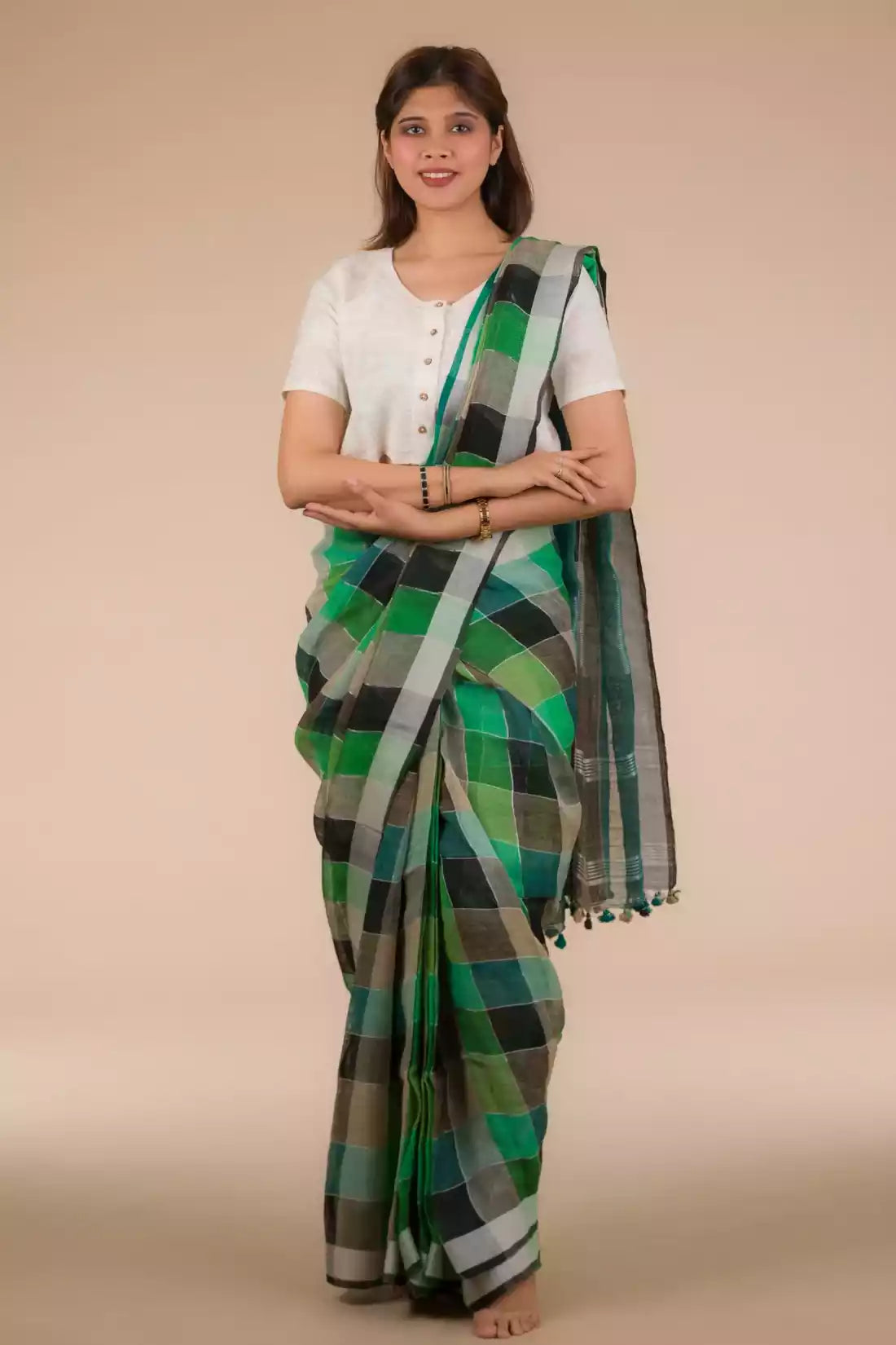 a beautiful woman with short hair wearing green checks saree with off-white blouse