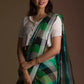 side view of a beautiful woman with short hair wearing green checks saree with off-white blouse