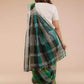 back view of a beautiful woman with short hair wearing green checks saree with off-white blouse