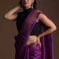 a beautiful woman wearing a purple saree with black blouse and gold accents on the border
