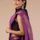 a beautiful woman looking sideways wearing a purple saree with black blouse and gold accents on the border