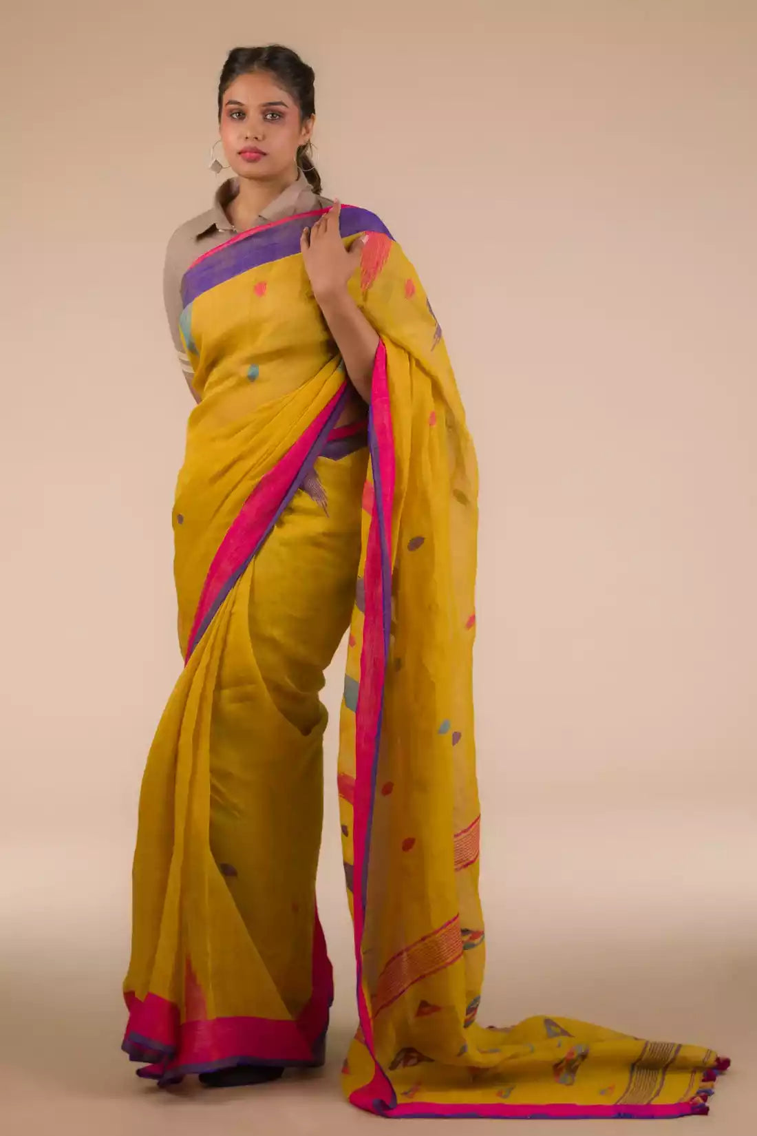 A beautiful lady in mustard with blue and pink border Jamdani hand weaving Saree, a office wear for women