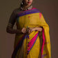 Aesthetically pleasing picture of a lady in a mustard with blue and pink border Jamdani hand weaving Saree