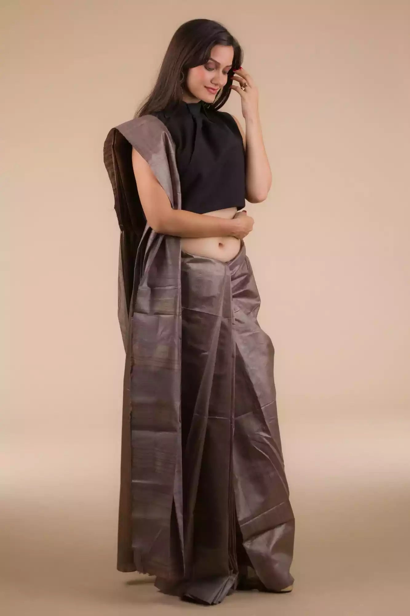 woman in ethnic posing wearing purple saree with black blouse looking towards the floor