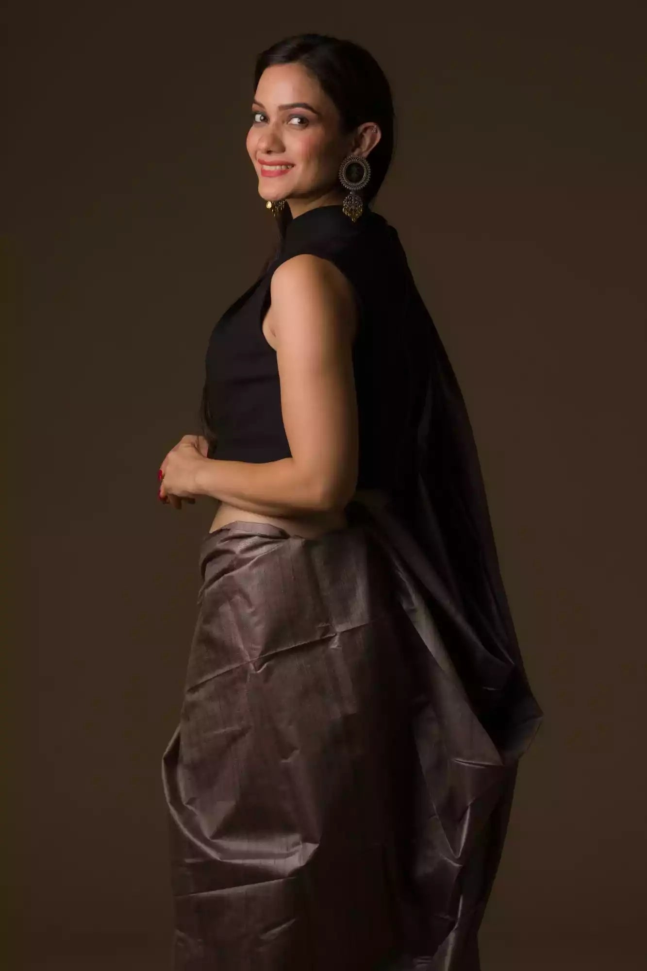 a woman with short hair is posing for the camera and she is wearing a purple saree and a black blouse