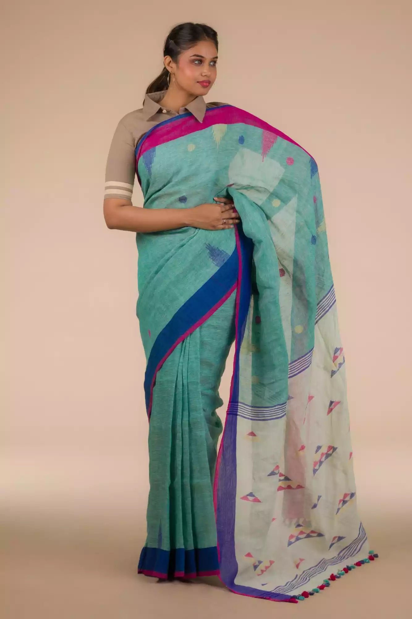 A lady in Light sea green Jamdani hand weaving In Pure Linen Saree standing against a beige background.