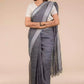 Woman standing in beige background wearing pure linen saree for office