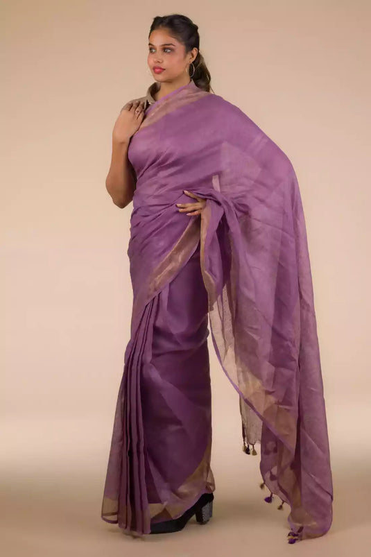 A lady in Mauve Bloom Linen Saree in Dark Purple, womens workwear standing against a beige background looking sideways