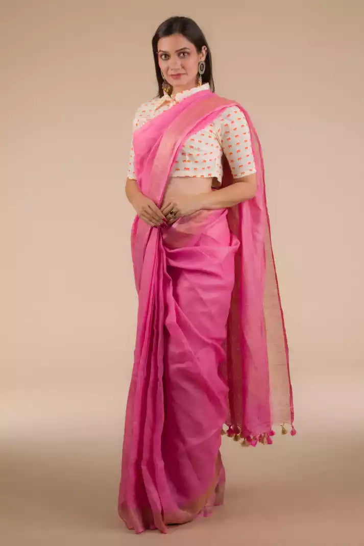 a beautiful woman wearing Pretty Pink Plain In Pure Linen Saree, women workwears is posed in front of a tan background