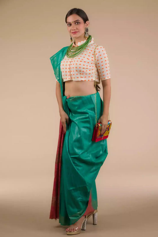 a beautiful woman wearing in Sea Green and Red Border Plain In Pure Tussar with Ghicha Border Saree , women workwears is posed in front of a tan background