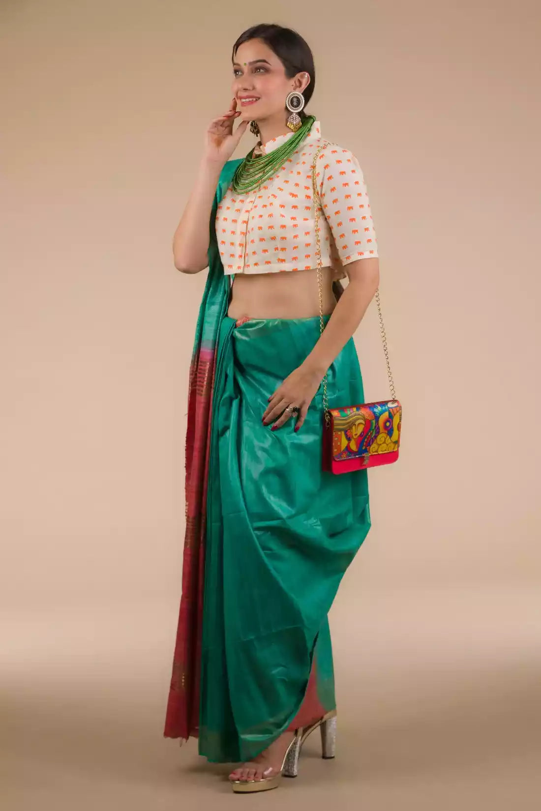 A lady in Sea Green and Red Border Plain In Pure Tussar with Ghicha Border Saree standing against a beige background