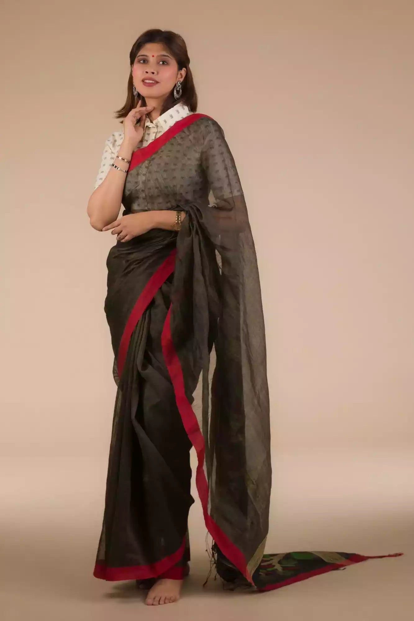 a beautiful woman with short hair wearing a chocolate brown saree with collared blouse