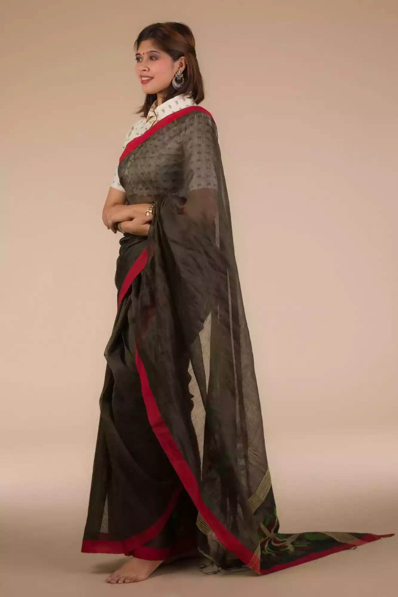 side view of a beautiful woman with short hair wearing a chocolate brown saree with collared blouse