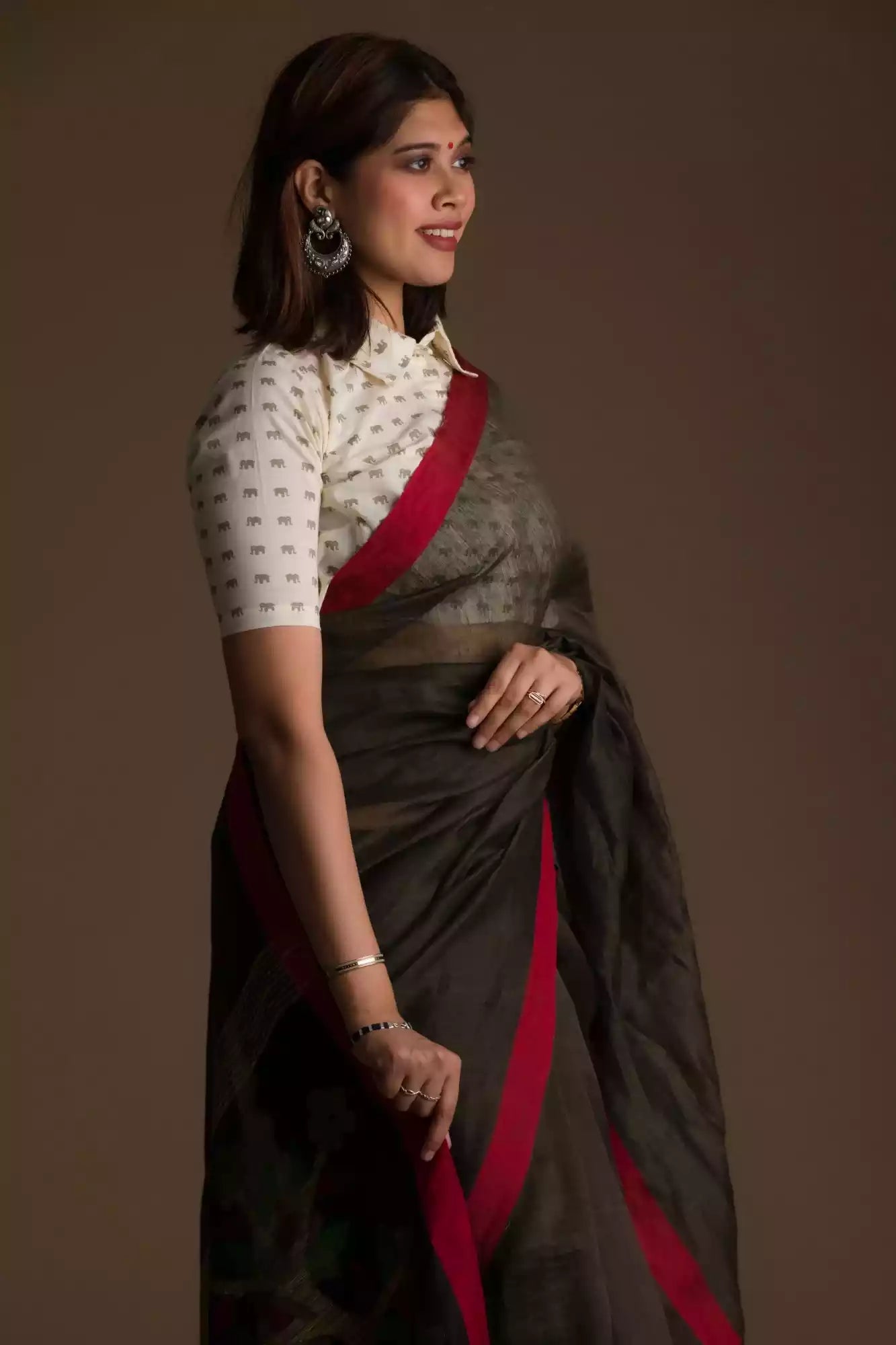 closure side view of a beautiful woman with short hair wearing a chocolate brown saree with collared blouse